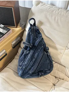 Vintage washed denim sling chest bag detail shot showing unique triangle shape and buckles.