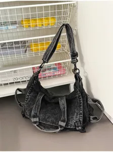 Close-up detail of vintage washed denim shoulder hobo bag, showing texture and metal rings.