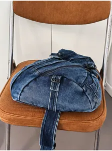 Detail view of retro washed denim chest bag with zipper and adjustable strap, vintage style.