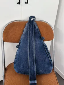 Vintage washed dark blue denim triangular sling chest bag, casual retro crossbody backpack.