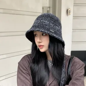 Close-up detail of dark grey knit bucket hat with stylish side straps and textured design.
