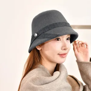 Close-up detail of the elegant grey wool bucket hat, featuring a stylish ribbon and pearl button.