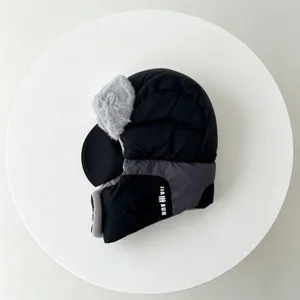 Detailed view of the thick fleece-lined black trapper hat with warm ear flaps for winter.