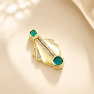 Geometrischer fächerförmiger Anhänger Detail mit Zirkonia und grünen Schmucksteinen.