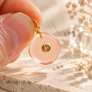 Detailopname van de prachtige roze steenhanger met doorschijnende textuur en gouden zetting.