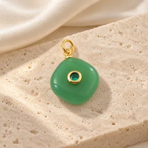 Gedetailleerde close-up van de groene snoepsteen hanger met vergulde metalen ring en kristal.