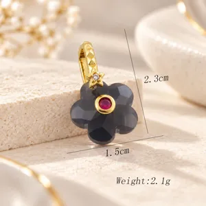 Detalle de colgante de flor de cinco pétalos, piedra negra facetada con centro rojo.