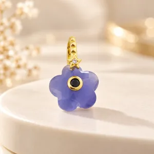 Exquisito colgante en forma de flor de cinco pétalos con piedra de color y circonita.