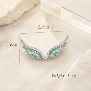 Connecteur de bijoux d'aile d'ange argenté avec des pierres de zircone vert et blanc scintillantes.