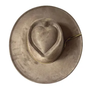 Detailed top view of brown suede cowboy hat featuring unique heart-shaped crown and tassel band.