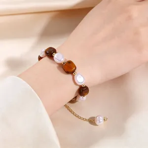 Close-up detail view of the elegant natural stone and pearl beaded bracelet worn on wrist.