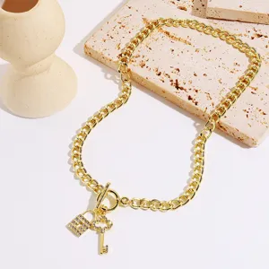 Detailed shot of gold chain necklace featuring rhinestone paved padlock and key pendants.