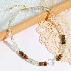 Detailed close-up of crystal heart pendant and colorful gemstone beaded layered necklace.