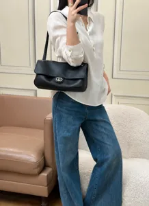 Vue détaillée d'un sac à épaule en cuir noir, design à rabat classique avec serrure.