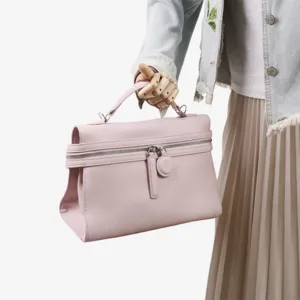 Vue detaillee du sac a main en cuir rose avec poignee, tenu par mannequin en studio.