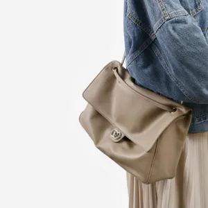 Vue détaillée d'un sac à bandoulière en cuir souple taupe avec fermoir tournant.
