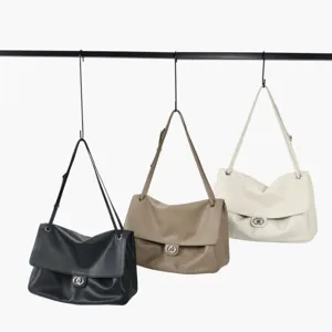 Vue détaillée de sacs à épaule souples en cuir suspendus en noir, kaki et blanc.