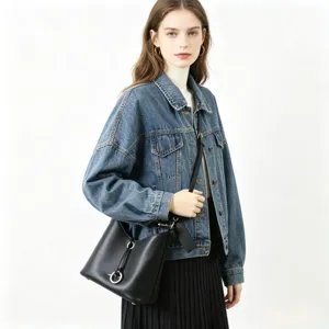Vue détaillée du sac seau en cuir noir avec fermeture à anneau métallique, élégant.
