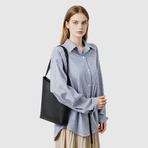 Dettaglio borsa a spalla in pelle nera, borsa minimalista spaziosa per uso quotidiano.