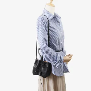 Vue de détail du sac seau en cuir noir avec motif perforé et ajouré de fleurs.