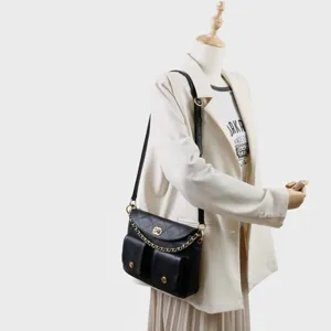 Sac bandoulière noir en cuir matelassé avec bandoulière chaîne et deux poches avant.