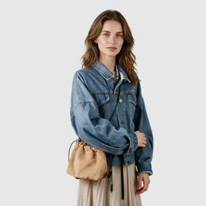 Gros plan sur le sac bandoulière élégant en suède avec cordon et matelassage chic.