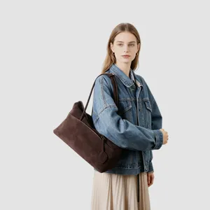 Détail de sac porté épaule en daim marron, élégant sac hobo rétro pour le quotidien.