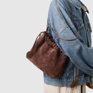Vue détaillée du sac seau bandoulière cordon en daim marron matelassé style mode femme.