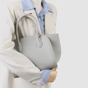 Sac cabas minimaliste en cuir gris détail, design de rabat incurvé élégant, sac à main spacieux.