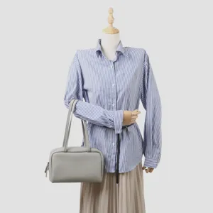 Vue rapprochée détaillée du sac porté épaule élégant en cuir véritable gris sur mannequin.