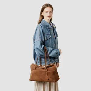 Vue détaillée du sac cabas en suède marron montrant sa texture douce et son élégant porté épaule.