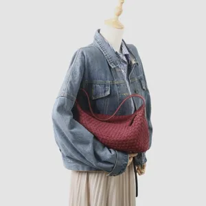 Détail sac bandoulière hobo en cuir tressé, design intrecciato bordeaux, sac élégant pour femme.
