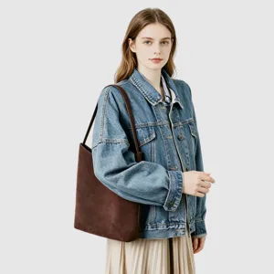 Détail du sac épaule en daim marron, mettant en valeur sa texture douce et sa grande capacité.
