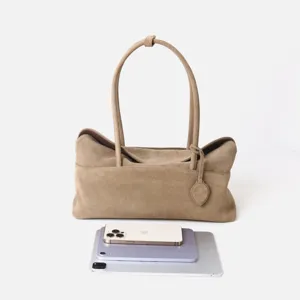 Vue détaillée du sac cabas en daim marron montrant son design horizontal et sa texture.