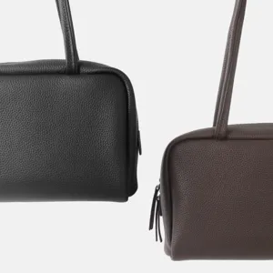 Vue détaillée du sac porté épaule de bowling en cuir véritable, montrant texture et fermeture.