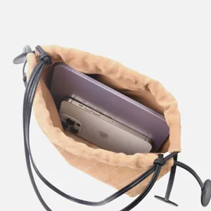 Sac seau en daim matelassé avec lanière en cuir noir montrant la capacité intérieure.