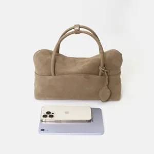 Vue détaillée du sac à main en daim marron, montrant sa texture fine et son cuir souple.