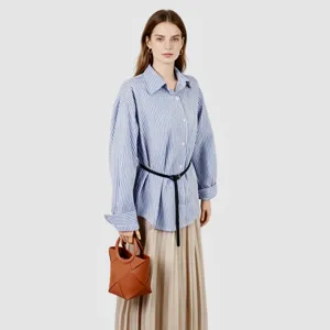 Detailed view of the brown geometric woven handbag with elegant handle and chic outfit.