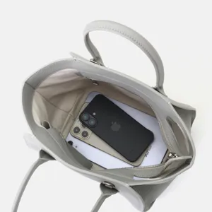 Vue détaillée de l'intérieur du sac en cuir gris montrant une grande capacité et finitions.