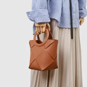 Brown geometric woven handbag detail, featuring unique folding design and stylish round handle.