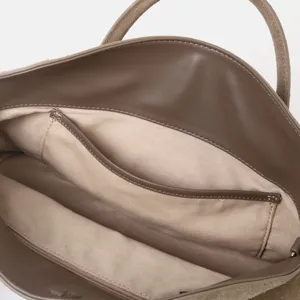 Vue détaillée de l'intérieur du sac cabas en cuir marron avec doublure et poches.