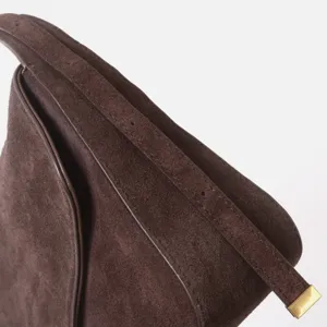 Détail de sac bandoulière en cuir daim marron, sacoche élégante pour femme pour le travail.