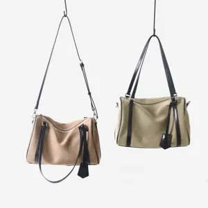 Détail du sac Boston en toile et cuir de vachette avec coutures et double bandoulière.