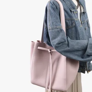 Vue detaillee du cabas en cuir rose, montrant la texture du cuir et le noeud elegant.