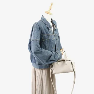 Vue détaillée d'un sac Boston élégant en cuir véritable avec coutures contrastées et lanière.
