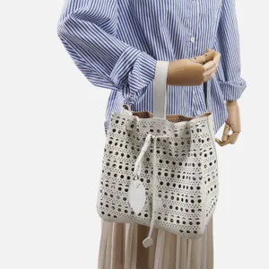 Grand sac seau ajouré en cuir blanc élégant sac à main perforé pour femmes chic.