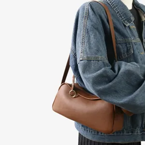 Gros plan du sac porté épaule marron en cuir véritable, texture souple et style élégant.