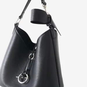 Gros plan sur le sac seau en cuir noir avec fermeture à anneau métallique et poignée.
