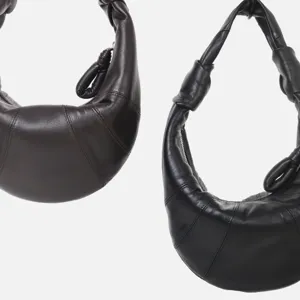 Vista detallada de bolsos hobo croissant de cuero plisado en marrón oscuro y negro.