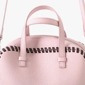 Vue détail sac Boston cuir rose avec surpiqûres contrastées sur les poignées élégantes.
